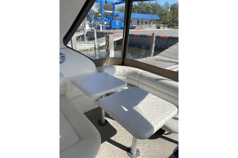 Slide: The Image of Interior of 2003 Cruisers Yachts 2870 Express with white seating and table, dockside view. - 7