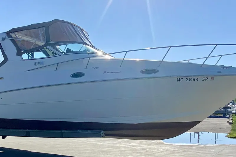 The Image of 2003 Cruisers Yachts 2870 Express boat on trailer, side view in marina setting. - 0