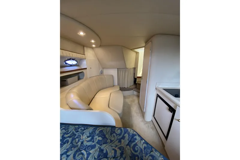 Slide: The Image of Interior of 2003 Cruisers Yachts 2870 Express, featuring a cozy seating area and compact kitchen. - 17