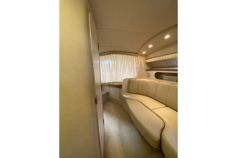 Slide: The Image of Interior of 2003 Cruisers Yachts 2870 Express, featuring beige seating and ambient lighting. - 19
