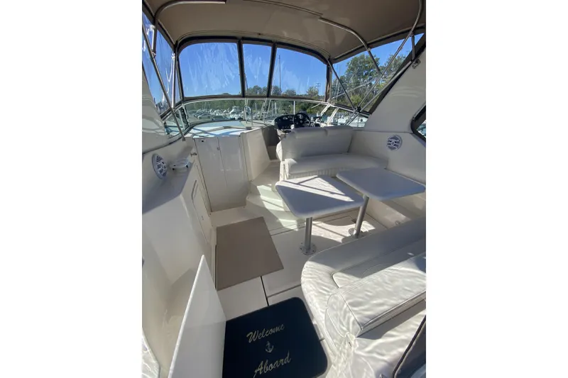 Slide: The Image of 2003 Cruisers Yachts 2870 Express interior with seating and helm, featuring "Welcome Aboard" mat. - 3