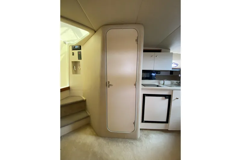 Slide: The Image of 2003 Cruisers Yachts 2870 Express interior with kitchenette and cabin door. - 9