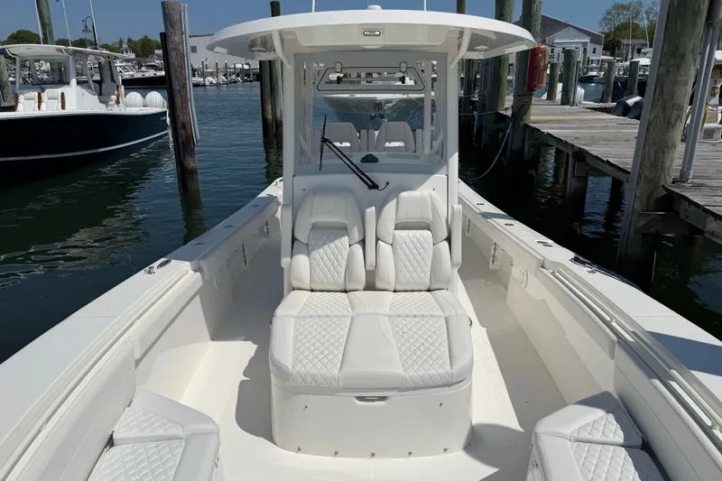Slide: The Image of 2025 Regulator 30XO boat with luxurious seating, docked at a marina. - 56