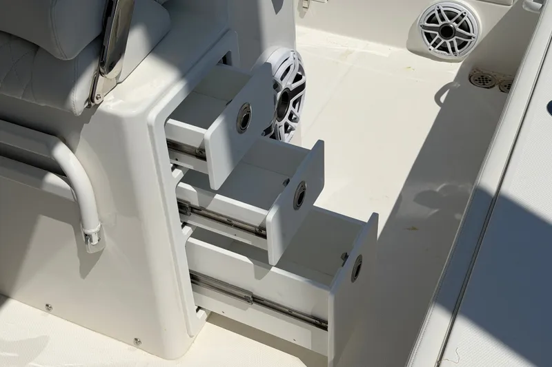 Slide: The Image of 2025 Regulator 30XO boat interior with open storage drawers and speaker system. - 30
