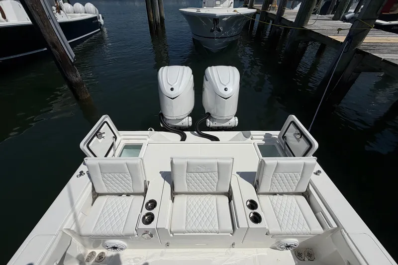 Slide: The Image of 2025 Regulator 30XO boat with dual engines and luxurious seating at a marina. - 19