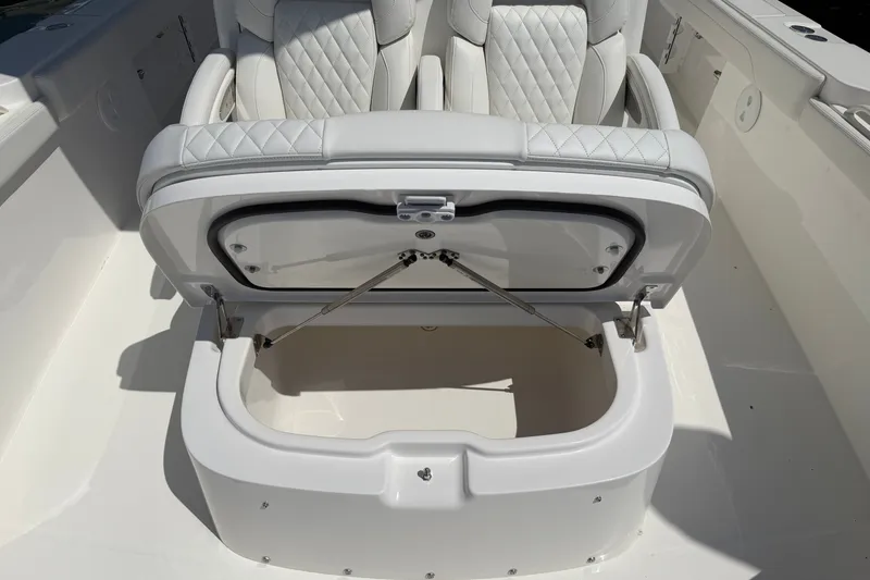 Slide: The Image of 2025 Regulator 30XO boat with open storage compartment and cushioned seating. - 58
