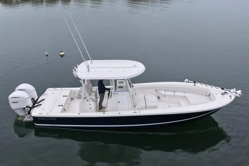 Slide: The Image of 2025 Regulator 30XO boat on calm water, featuring dual Yamaha engines. - 12
