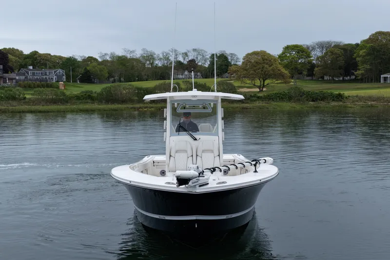 Slide: The Image of 2025 Regulator 30XO boat on calm water, surrounded by lush greenery. - 3