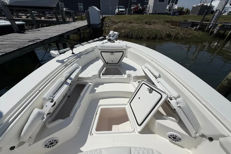 Slide: The Image of 2025 Regulator 30XO boat interior with open storage compartments at dockside. - 49
