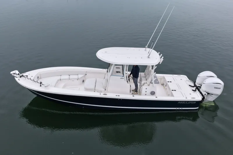 Slide: The Image of 2025 Regulator 30XO boat with dual Yamaha engines on calm water. - 14