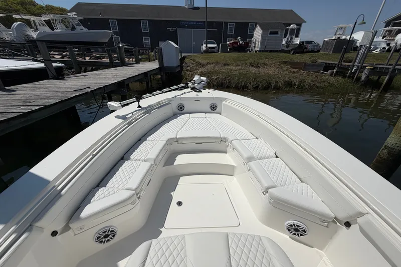 Slide: The Image of 2025 Regulator 30XO boat with white cushioned seating at a dock. - 48