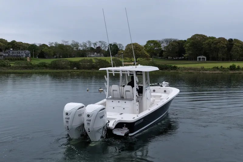Slide: The Image of 2025 Regulator 30XO boat with twin Yamaha 350 engines on a calm lake. - 10