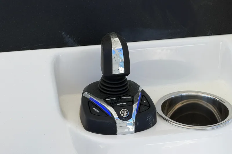 Slide: The Image of Joystick control on 2025 Regulator 30XO boat dashboard, next to a cup holder. - 37