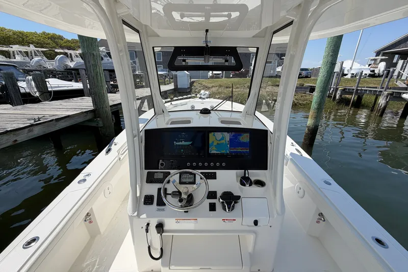 Slide: The Image of 2025 Regulator 30XO boat cockpit with advanced navigation system at a marina dock. - 31
