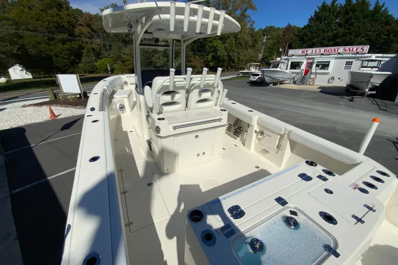 Slide: The Image of 2025 Cobia 285 Open Center Console boat at dealership, showcasing spacious deck and seating. - 11
