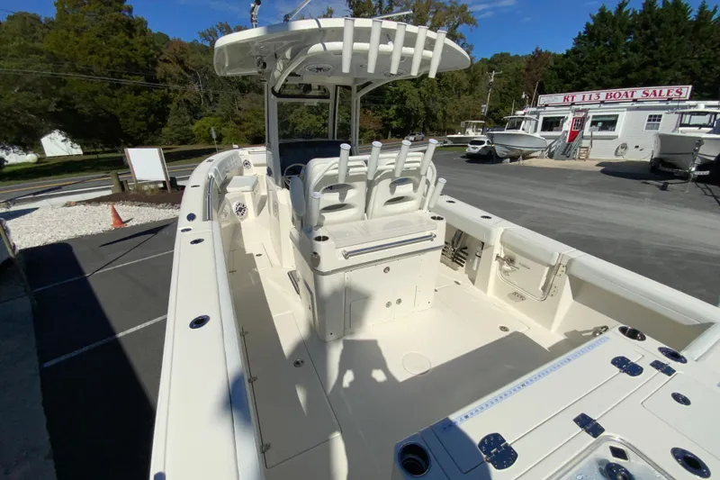 Slide: The Image of 2025 Cobia 285 Open Center Console boat at dealership, showcasing spacious deck and seating. - 12