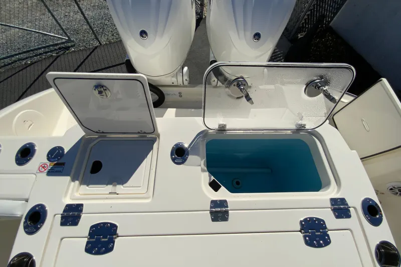 Slide: The Image of 2025 Cobia 285 Open Center Console boat with open storage compartments and dual engines. - 17