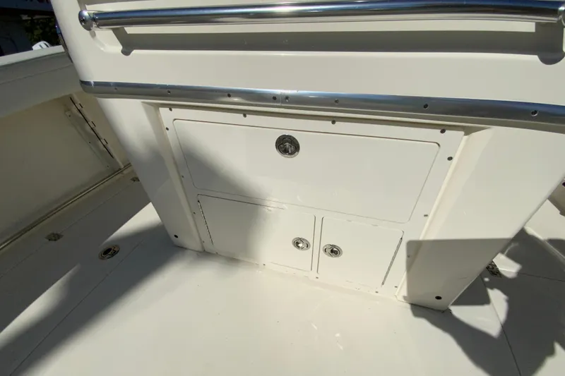 Slide: The Image of 2025 Cobia 285 Open Center Console storage compartment with stainless steel railings. - 21