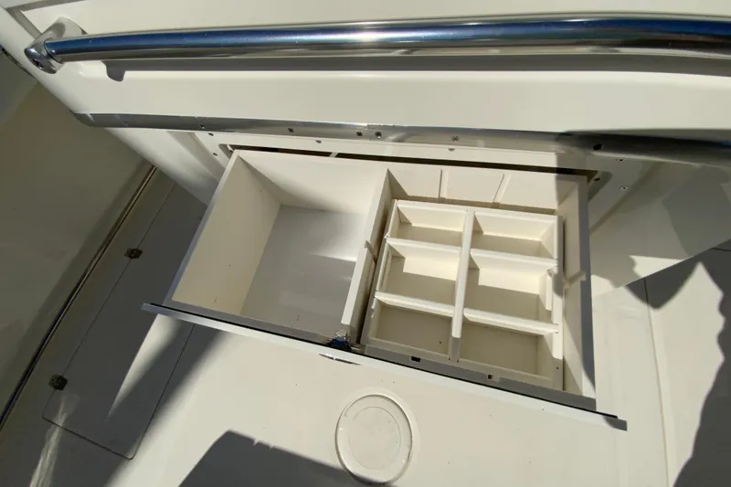 Slide: The Image of 2025 Cobia 285 Open Center Console storage compartment with dividers, open view. - 22