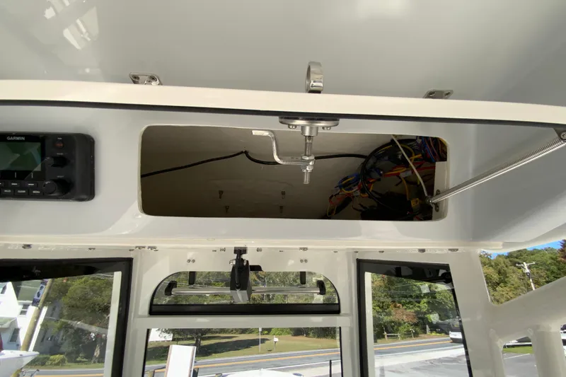 Slide: The Image of 2025 Cobia 285 Open Center Console boat interior with open storage compartment and wiring. - 32