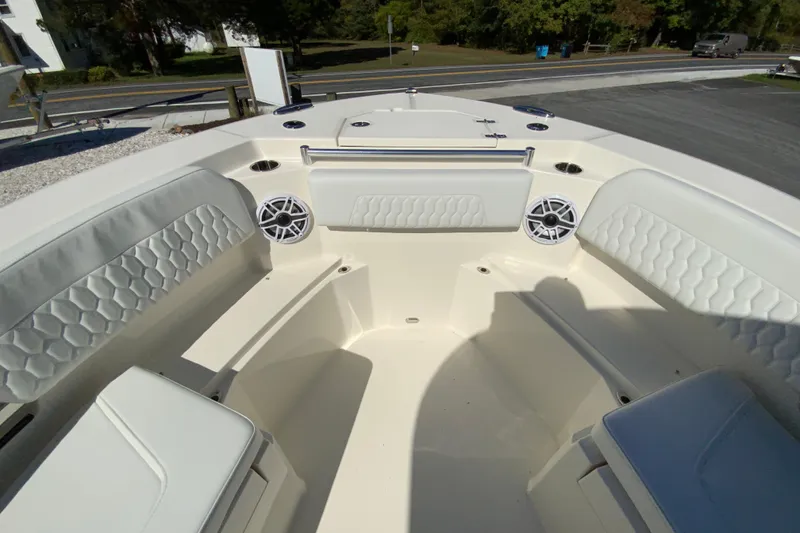 Slide: The Image of 2025 Cobia 285 Open Center Console boat interior with cushioned seating and speakers. - 35