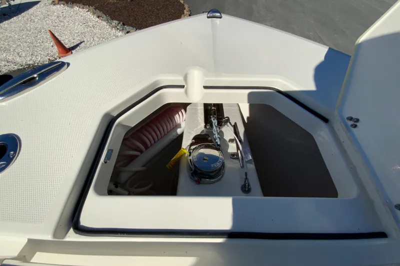 Slide: The Image of 2025 Cobia 285 Open Center Console anchor storage compartment with winch and rope. - 36