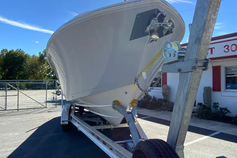 Slide: The Image of 2025 Cobia 285 Open Center Console boat on trailer, parked outdoors. - 4
