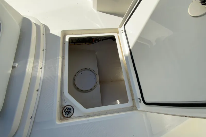 Slide: The Image of 2025 Cobia 285 Open Center Console storage compartment with open hatch. - 40