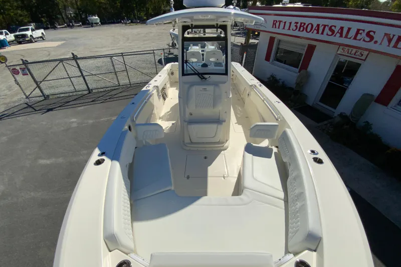 Slide: The Image of 2025 Cobia 285 Open Center Console boat at dealership, showcasing spacious seating and helm. - 43