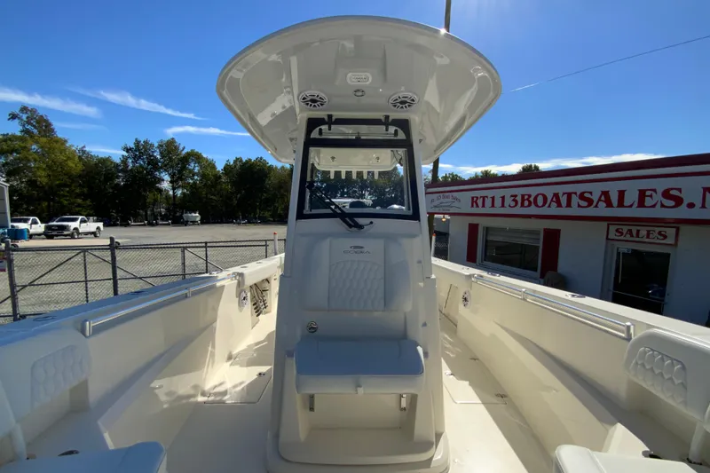 Slide: The Image of 2025 Cobia 285 Open Center Console boat at dealership, showcasing helm and seating area. - 44