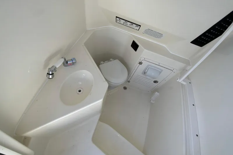 Slide: The Image of 2025 Cobia 285 Open Center Console boat interior with sink and toilet. - 47