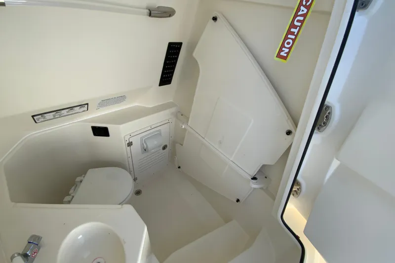 Slide: The Image of 2025 Cobia 285 Open Center Console boat interior with toilet and sink. - 48