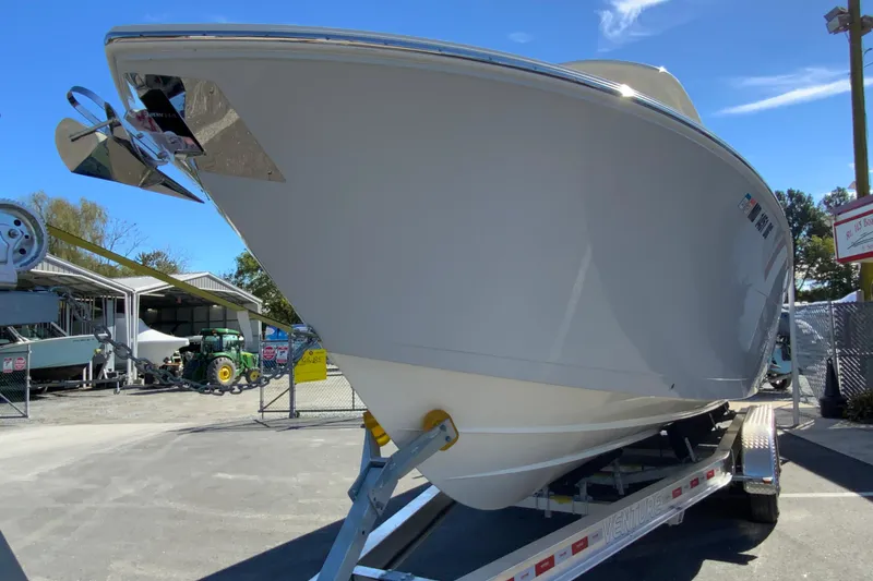 Slide: The Image of 2025 Cobia 285 Open Center Console boat on trailer in outdoor setting. - 5