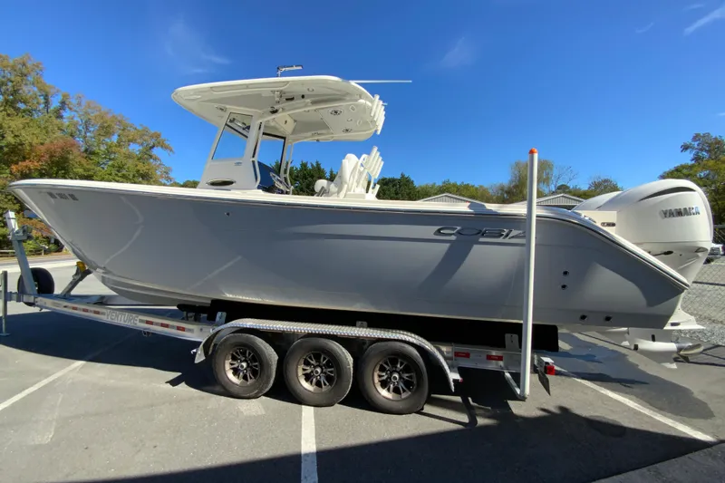 Slide: The Image of 2025 Cobia 285 Open Center Console boat on trailer, sunny day. - 7
