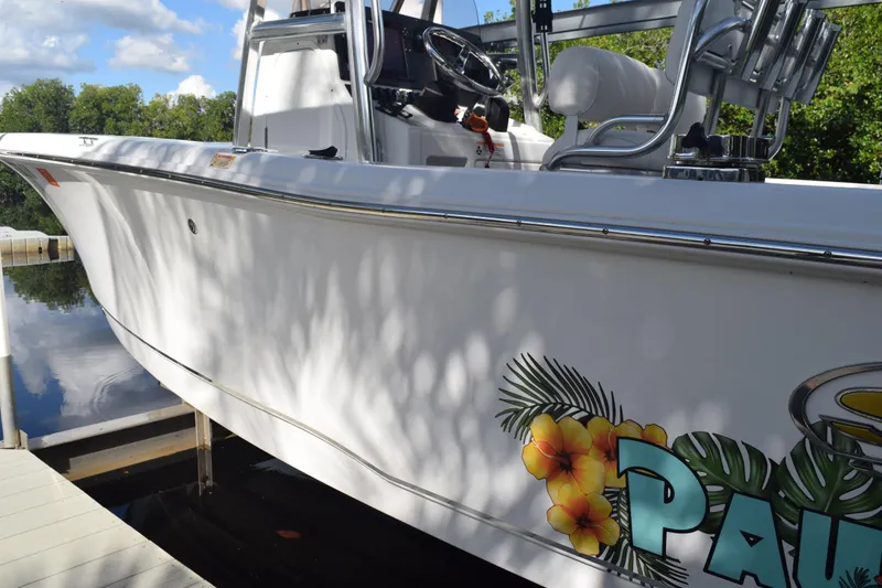 Slide: The Image of 2018 Sea Hunt Ultra 211 boat docked, featuring tropical floral graphics. - 10