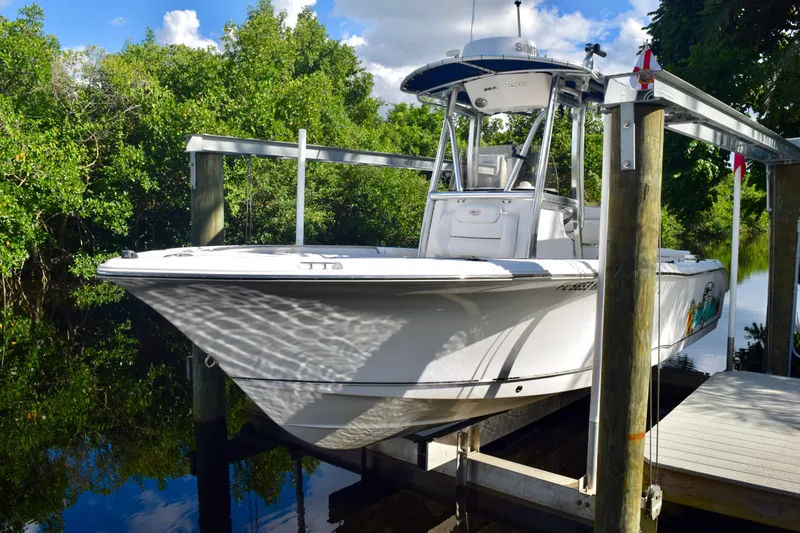 Slide: The Image of 2018 Sea Hunt Ultra 211 boat docked near lush greenery and calm water. - 12