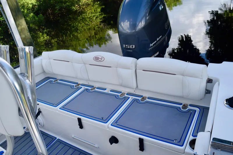 Slide: The Image of 2018 Sea Hunt Ultra 211 boat interior with Yamaha 150 engine, featuring cushioned seating. - 14