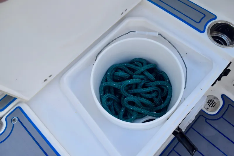 Slide: The Image of 2018 Sea Hunt Ultra 211 boat storage compartment with coiled green rope. - 20