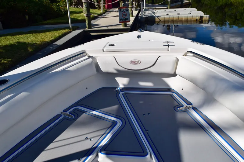 Slide: The Image of 2018 Sea Hunt Ultra 211 boat interior with sleek seating and modern design at a dock. - 23