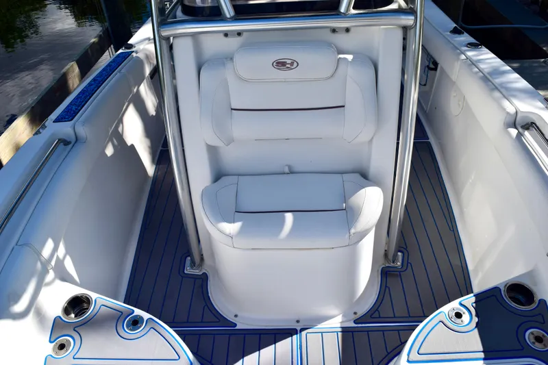 Slide: The Image of 2018 Sea Hunt Ultra 211 boat interior with white seating and blue-trimmed flooring. - 24