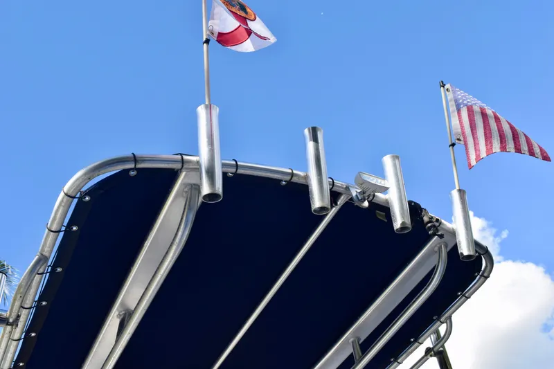 Slide: The Image of 2018 Sea Hunt Ultra 211 boat with flags against blue sky. - 26
