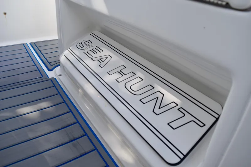 Slide: The Image of 2018 Sea Hunt Ultra 211 boat deck with branded mat and blue accents. - 32