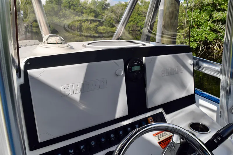 Slide: The Image of 2018 Sea Hunt Ultra 211 boat dashboard with Simrad navigation system and steering wheel. - 34