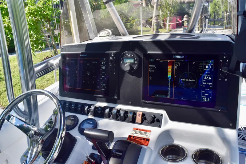 Slide: The Image of 2018 Sea Hunt Ultra 211 boat dashboard with Simrad navigation displays and controls. - 35