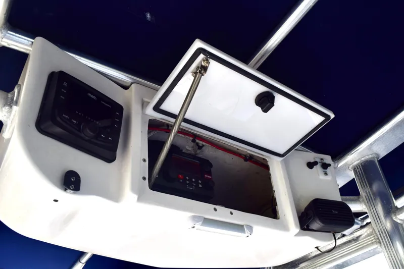 Slide: The Image of 2018 Sea Hunt Ultra 211 boat console with open storage compartment and electronic controls. - 42