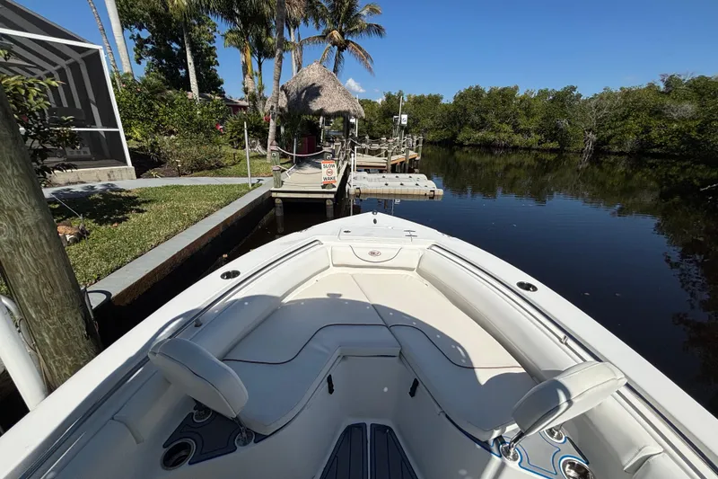 Slide: The Image of 2018 Sea Hunt Ultra 211 boat docked by a serene, tropical canal. - 58