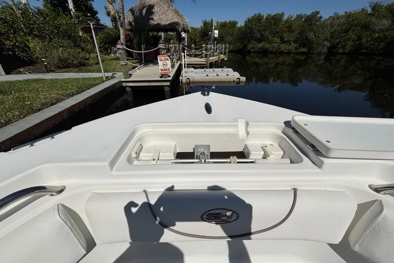 Slide: The Image of 2018 Sea Hunt Ultra 211 boat docked near lush greenery and calm waters. - 60