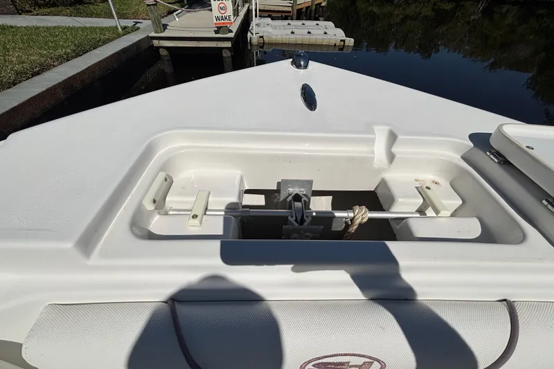 Slide: The Image of 2018 Sea Hunt Ultra 211 boat anchor compartment near dock. - 61
