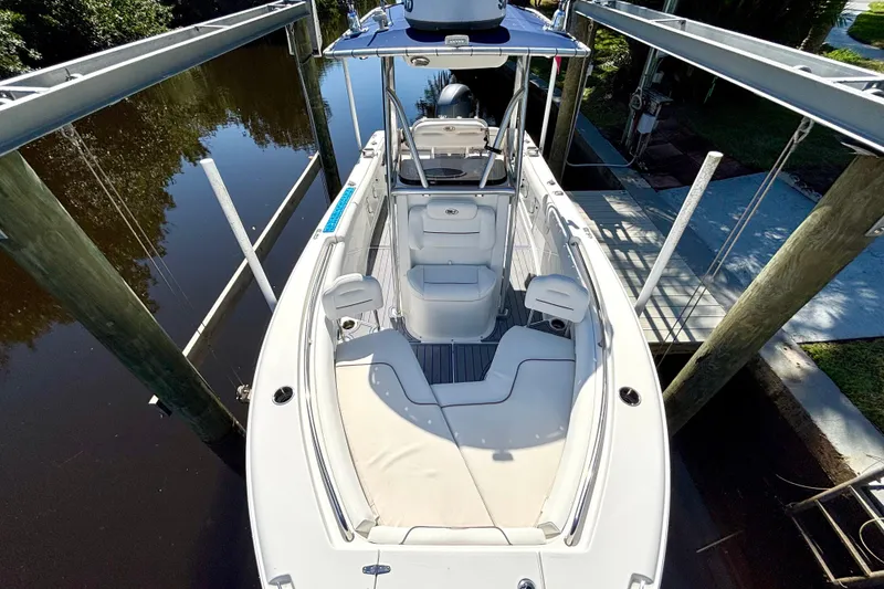 Slide: The Image of 2018 Sea Hunt Ultra 211 boat on lift, docked by calm water. - 63