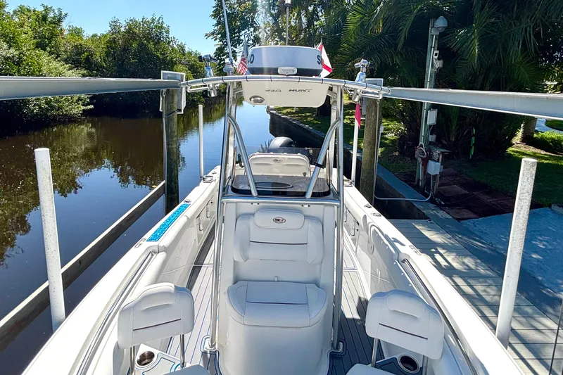 Slide: The Image of 2018 Sea Hunt Ultra 211 boat docked by a serene canal with lush greenery. - 66